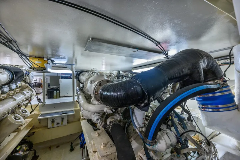 Slide: The Image of Engine room of 1999 Viking 60 Cockpit Motor Yacht, showcasing complex machinery and piping. - 38