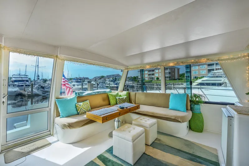 Slide: The Image of Luxurious interior of 1999 Viking 60 Cockpit Motor Yacht with marina view. - 12