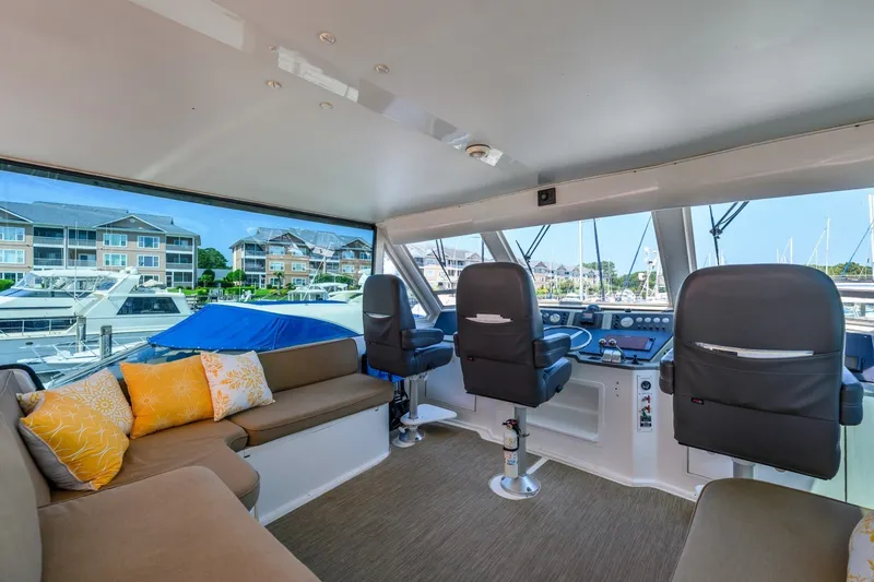 Slide: The Image of Interior of 1999 Viking 60 Cockpit Motor Yacht with helm and seating area. - 9
