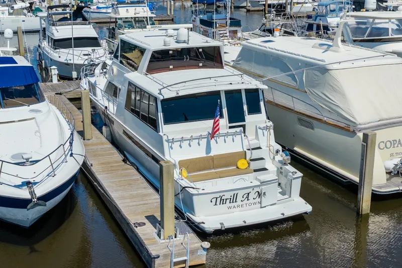 Slide: The Image of 1999 Viking 60 Cockpit Motor Yacht docked at marina, rear view with American flag. - 5