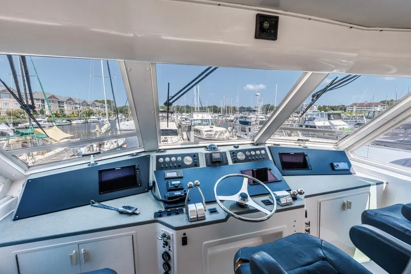 Slide: The Image of Cockpit view of 1999 Viking 60 Cockpit Motor Yacht with marina background. - 7
