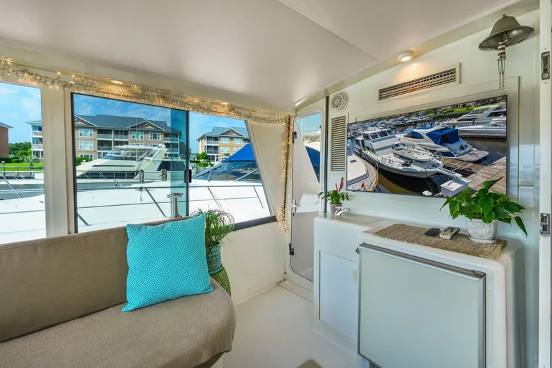 Slide: The Image of Interior of 1999 Viking 60 Cockpit Motor Yacht with cozy seating and marina view. - 11