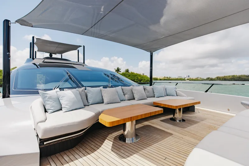 Slide: The Image of Luxurious 2024 Mangusta 104 REV yacht deck with elegant seating and tables, under a shaded canopy. - 66