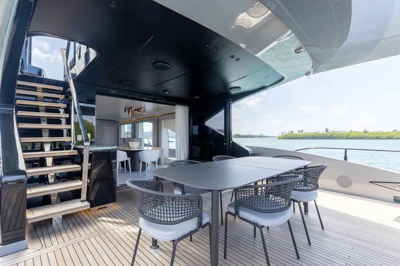 Slide: The Image of Luxurious 2024 Mangusta 104 REV yacht deck with elegant dining area and scenic ocean view. - 14