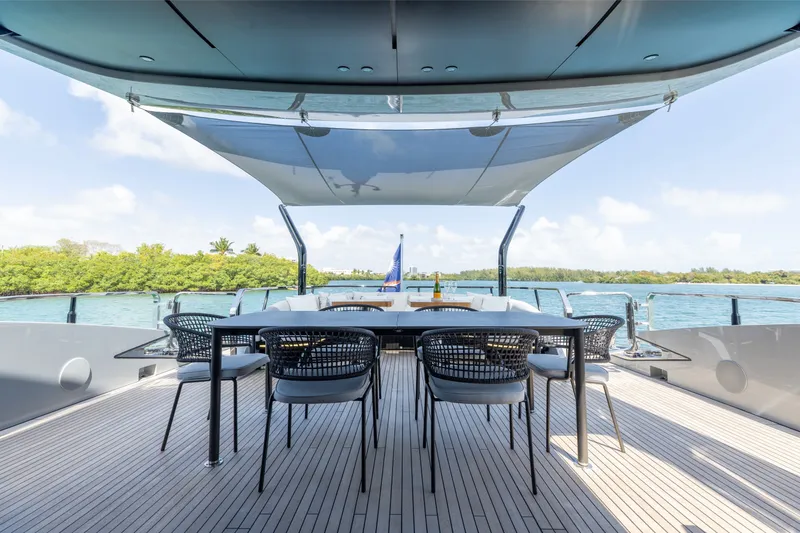 Slide: The Image of Luxurious deck of 2024 Mangusta 104 REV yacht with dining area and scenic water view. - 12