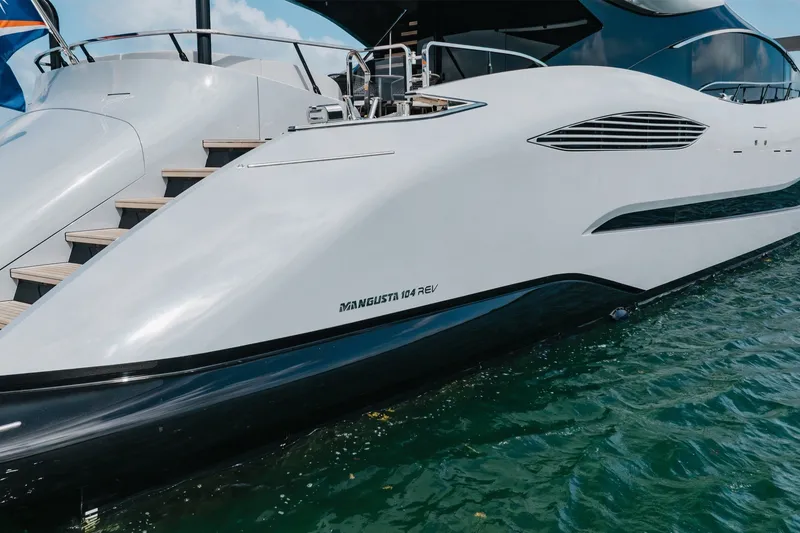 Slide: The Image of Luxury 2024 Mangusta 104 REV yacht docked, showcasing sleek design and elegant curves. - 11