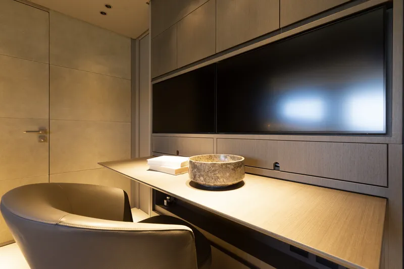Slide: The Image of Luxurious interior of 2024 Mangusta 104 REV yacht with modern desk and seating. - 45