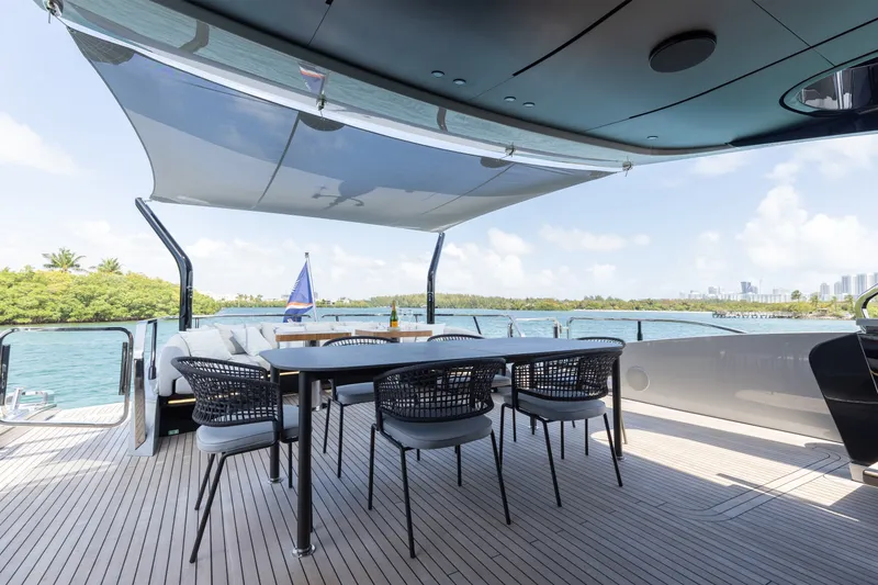 Slide: The Image of Luxurious 2024 Mangusta 104 REV yacht deck with dining area and scenic ocean view. - 13