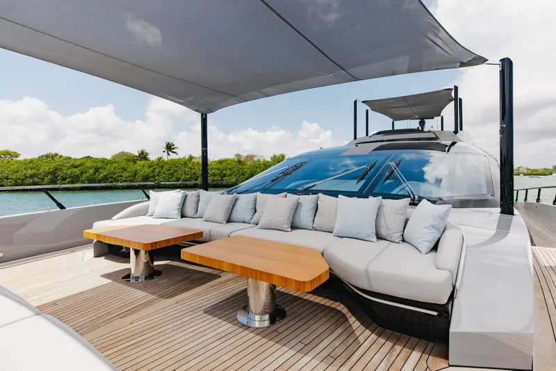Slide: The Image of Luxurious 2024 Mangusta 104 REV yacht deck with elegant seating and tables under canopy. - 64