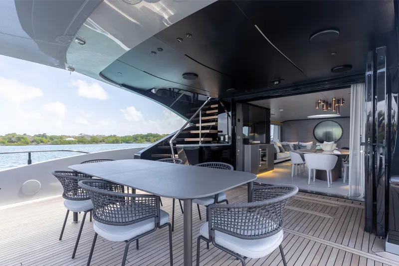 Slide: The Image of Luxurious 2024 Mangusta 104 REV yacht with elegant outdoor dining and modern interior design. - 5