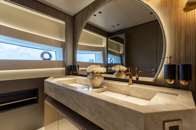 Slide: The Image of Luxurious bathroom interior of 2024 Mangusta 104 REV yacht with elegant marble sink and round mirror. - 31