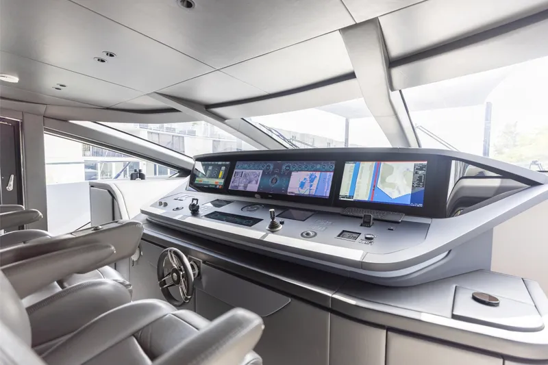 Slide: The Image of 2024 Mangusta 104 REV yacht cockpit with advanced navigation displays and luxurious seating. - 49