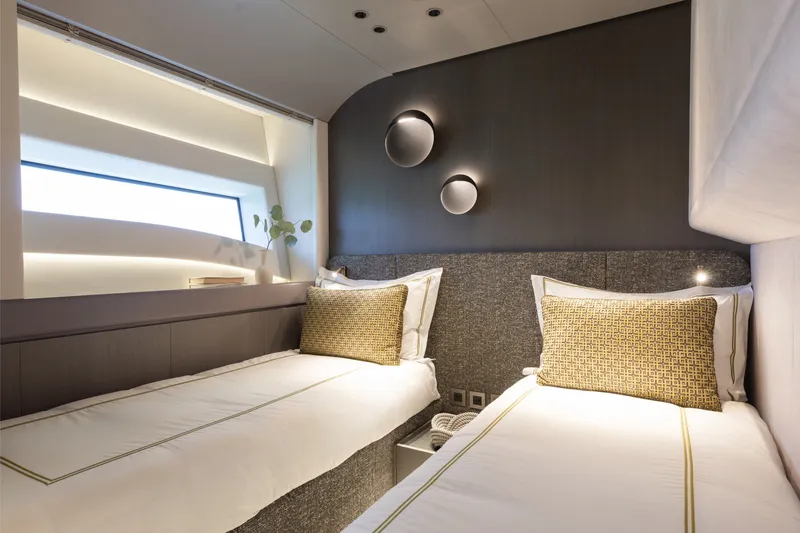 Slide: The Image of Luxurious twin cabin interior of 2024 Mangusta 104 REV yacht, featuring modern design and ambient lighting. - 41