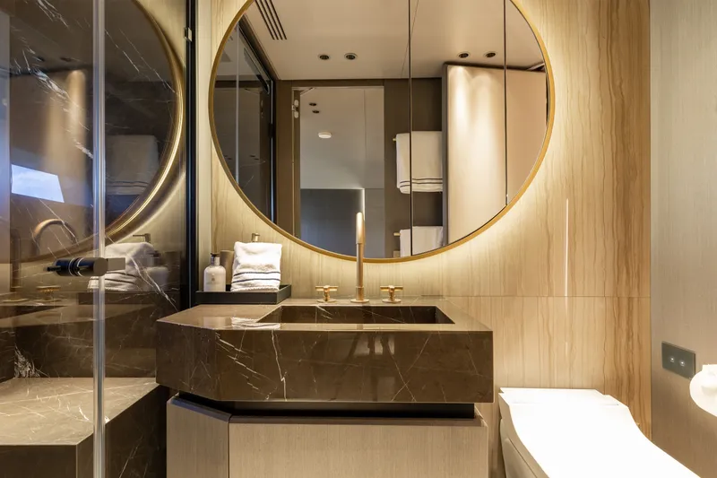 Slide: The Image of Luxurious bathroom in 2024 Mangusta 104 REV yacht, featuring elegant marble sink and round mirror. - 44