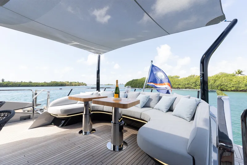 Slide: The Image of Luxurious 2024 Mangusta 104 REV yacht deck with elegant seating and scenic water view. - 59