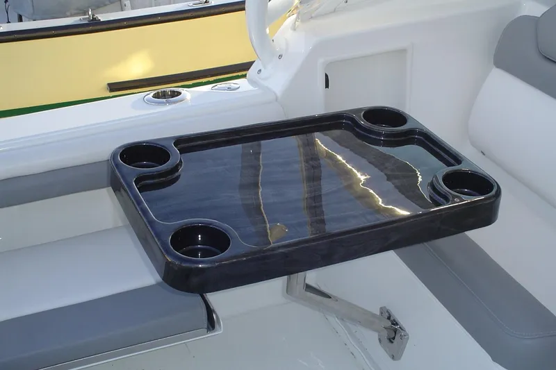 Slide: The Image of 2024 Albemarle 27 Dual Console boat interior with a sleek black table and cup holders. - 40