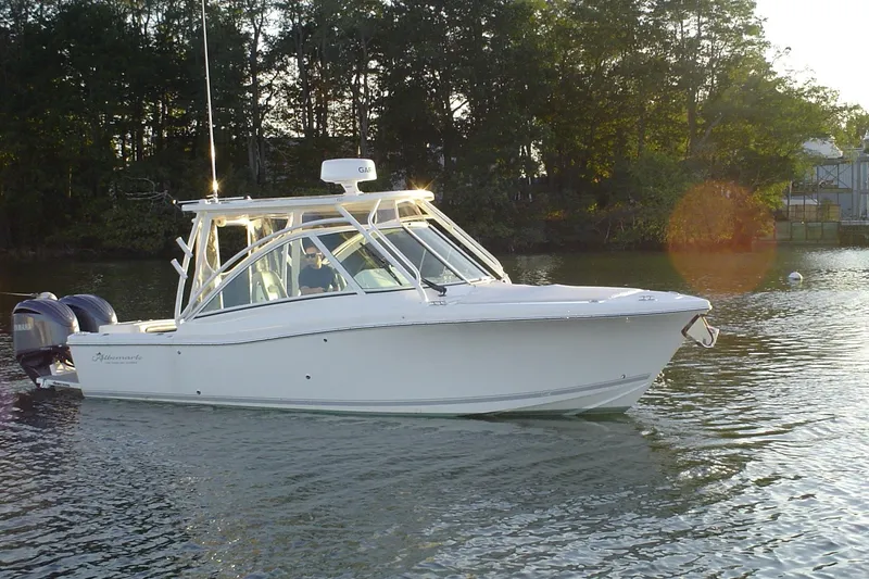 The Image of 2024 Albemarle 27 Dual Console boat on calm water, surrounded by trees. - 1