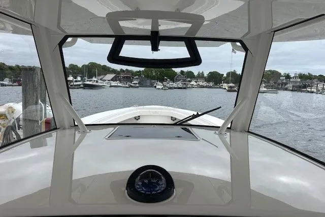 Slide: The Image of 2022 Regulator 41 boat cockpit view, overlooking marina with calm waters and docked boats. - 16