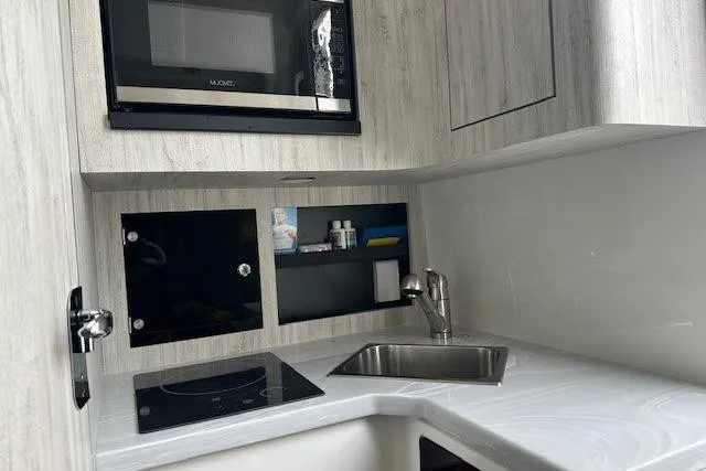 Slide: The Image of Modern kitchenette in 2022 Regulator 41 boat with sink, stove, and microwave. - 22