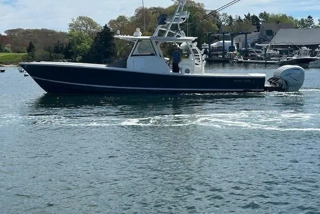 Slide: The Image of 2022 Regulator 41 boat cruising on a calm waterway with scenic background. - 40