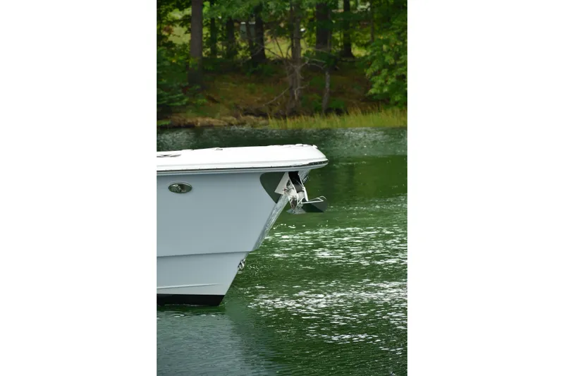 Slide: The Image of 2022 Everglades 335 Center Console boat on a serene lake with lush greenery. - 4