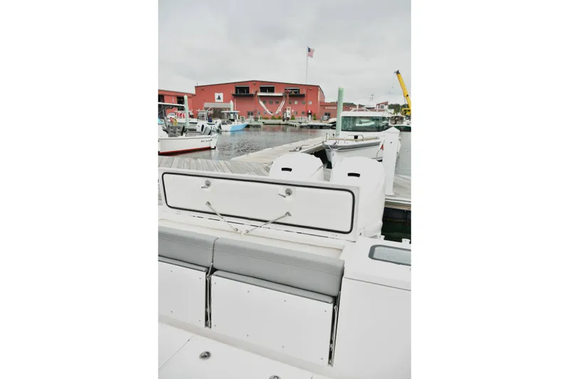Slide: The Image of 2022 Everglades 335 Center Console boat docked at marina with red building backdrop. - 17
