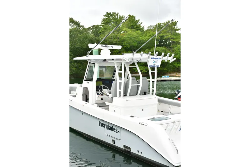Slide: The Image of 2022 Everglades 335 Center Console boat docked, featuring Garmin equipment and sleek design. - 21