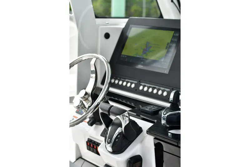 Slide: The Image of 2022 Everglades 335 Center Console dashboard with steering wheel and navigation display. - 7