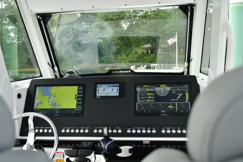 Slide: The Image of 2022 Everglades 335 Center Console boat dashboard with navigation screens and controls. - 9