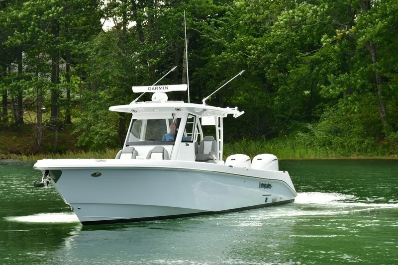 Slide: The Image of 2022 Everglades 335 Center Console boat cruising on a serene lake. - 2