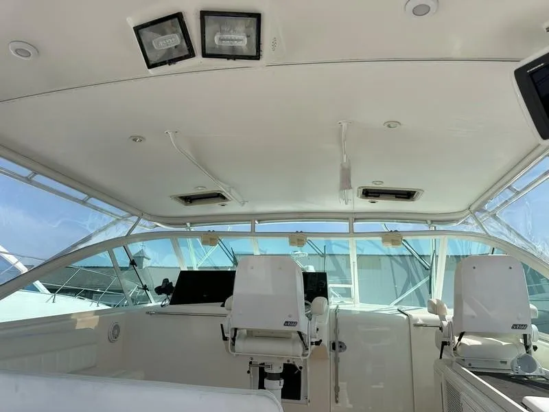 Slide: The Image of 2004 Cabo Express boat interior with helm chairs and navigation equipment. - 26