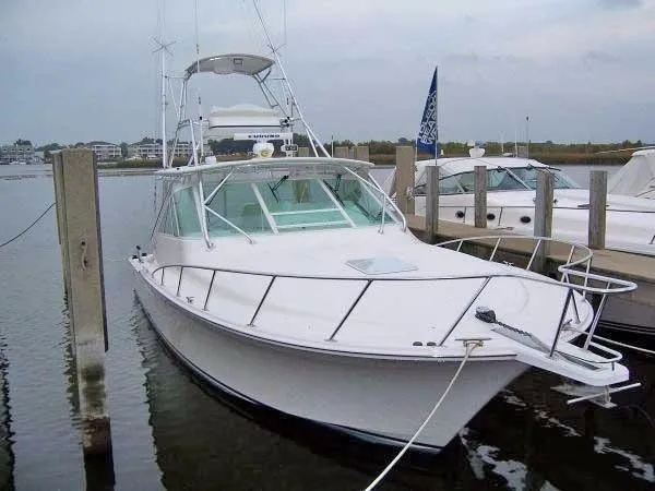 Slide: The Image of 2004 Cabo Express boat docked at marina, overcast sky, calm water. - 17