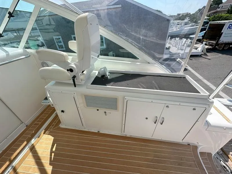 Slide: The Image of 2004 Cabo Express boat interior with captain's chair and storage cabinets. - 28