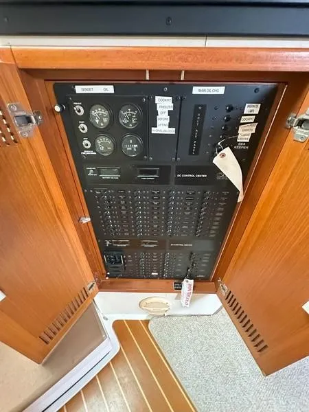 Slide: The Image of 2004 Cabo Express electrical control panel with wooden cabinet doors open. - 36