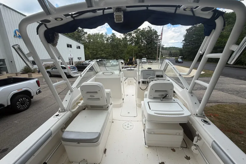 Slide: The Image of 2012 Everglades 230 Dual Console boat with seating and steering wheel, parked outdoors. - 9