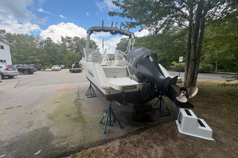 Slide: The Image of 2012 Everglades 230 Dual Console boat on stands, parked outdoors near trees. - 4