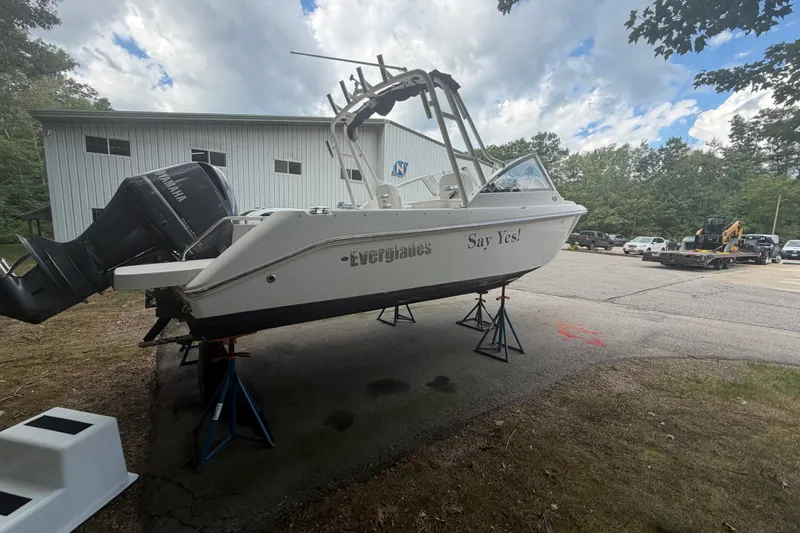 The Image of 2012 Everglades 230 Dual Console boat on stands, outdoors near a building. - 0