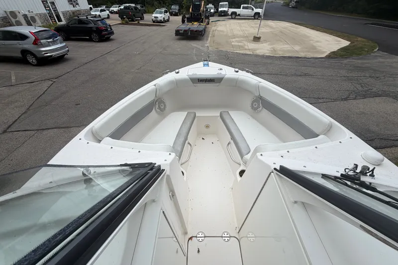Slide: The Image of 2012 Everglades 230 Dual Console boat interior with seating, parked in a lot. - 11