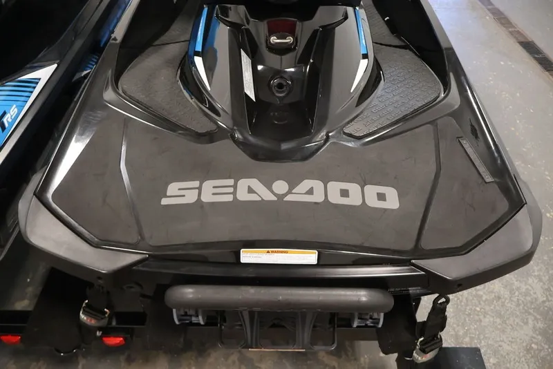 Slide: The Image of 2018 Sea-Doo RXT 230 jet ski, black with blue accents, parked indoors. - 34