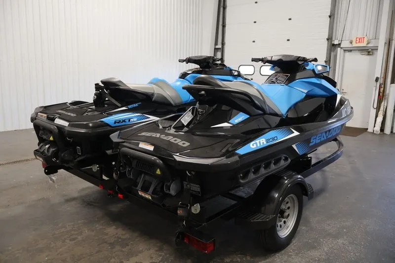 Slide: The Image of 2018 Sea-Doo RXT 230 jet skis on trailer in indoor garage setting. - 21