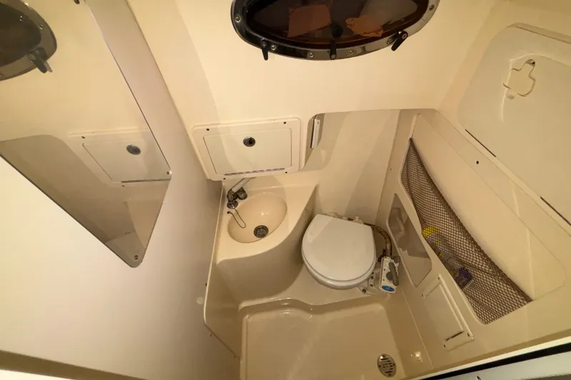 Slide: The Image of 2007 Scout 262 Abaco boat bathroom with sink, toilet, and storage compartments. - 16