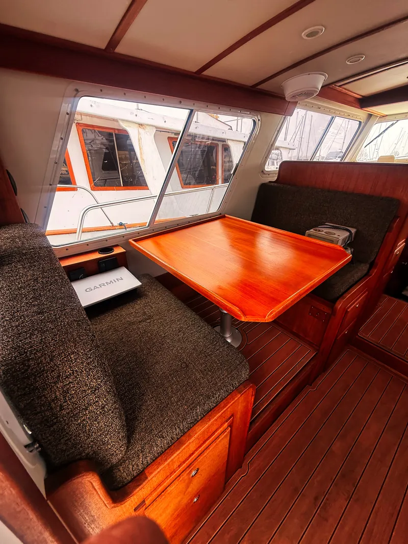 Slide: The Image of Interior of the 2005 SeaSport Voyager 3000 with a wooden table and cushioned seating. - 2