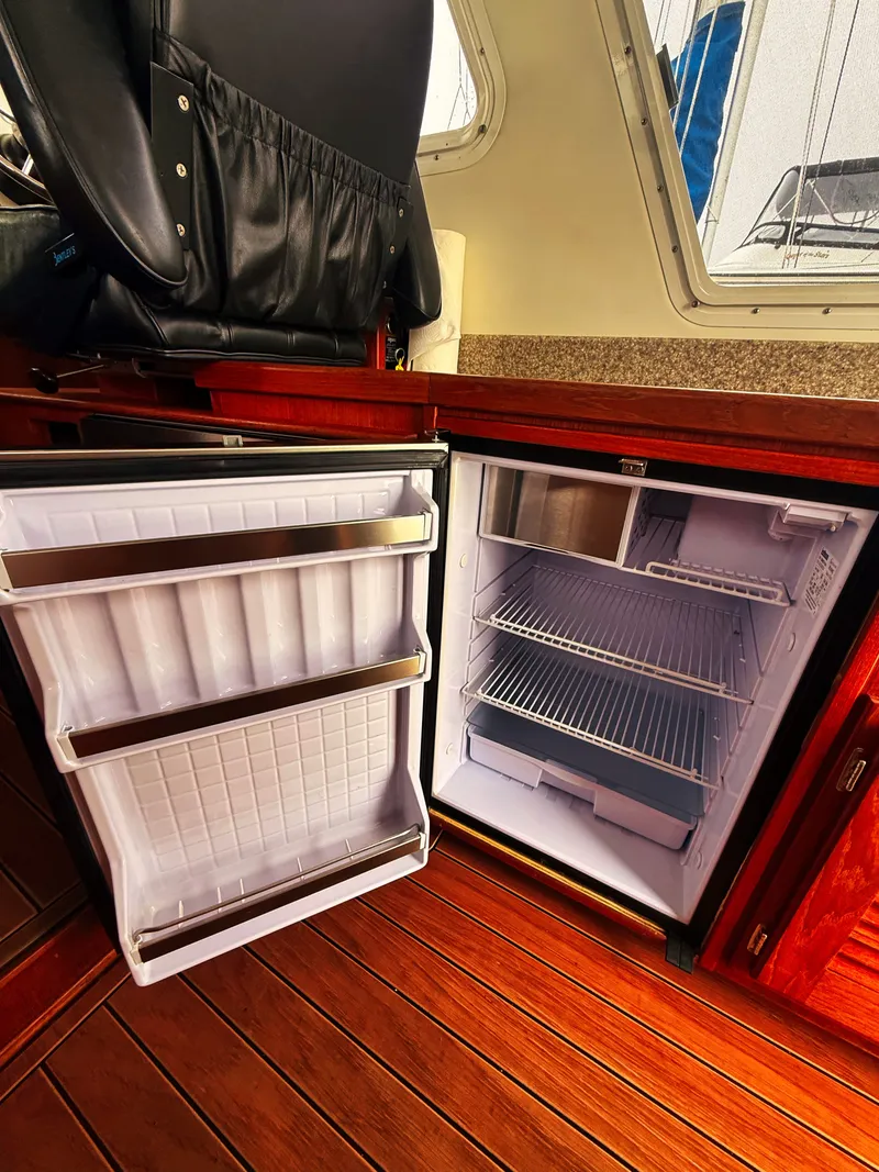 Slide: The Image of Interior of the 2005 SeaSport Voyager 3000 with an open fridge and wooden flooring. - 9