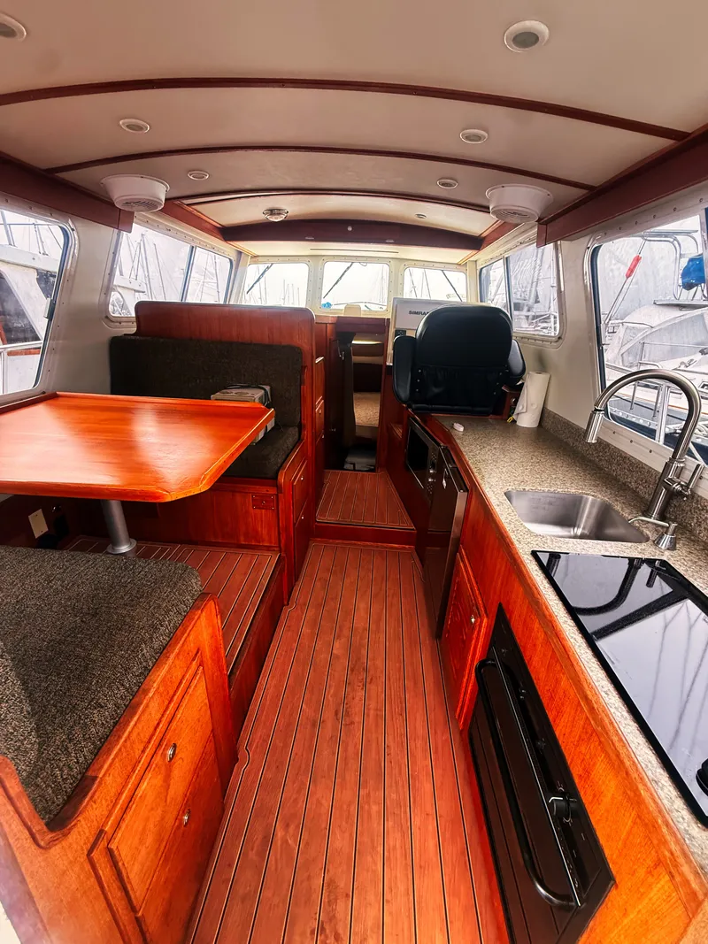 Slide: The Image of Interior of a 2005 SeaSport Voyager 3000 with wood flooring, kitchen, and seating area. - 1