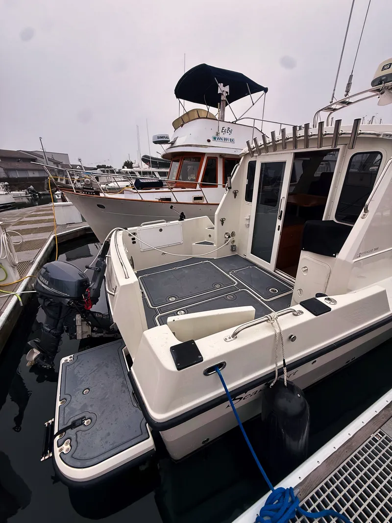 Slide: The Image of A 2005 SeaSport Voyager 3000 docked. It features an open stern and an outboard motor. - 19