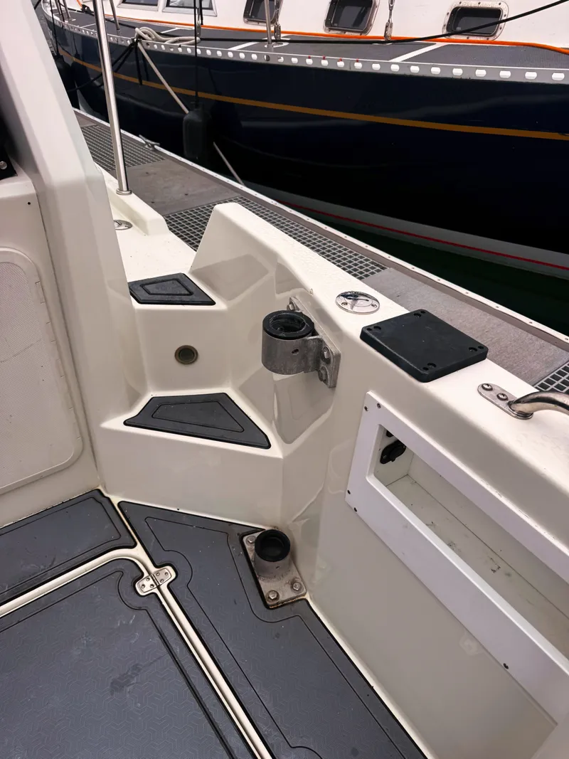 Slide: The Image of The image shows the deck of a 2005 SeaSport Voyager 3000 boat with fishing rod holders. - 26