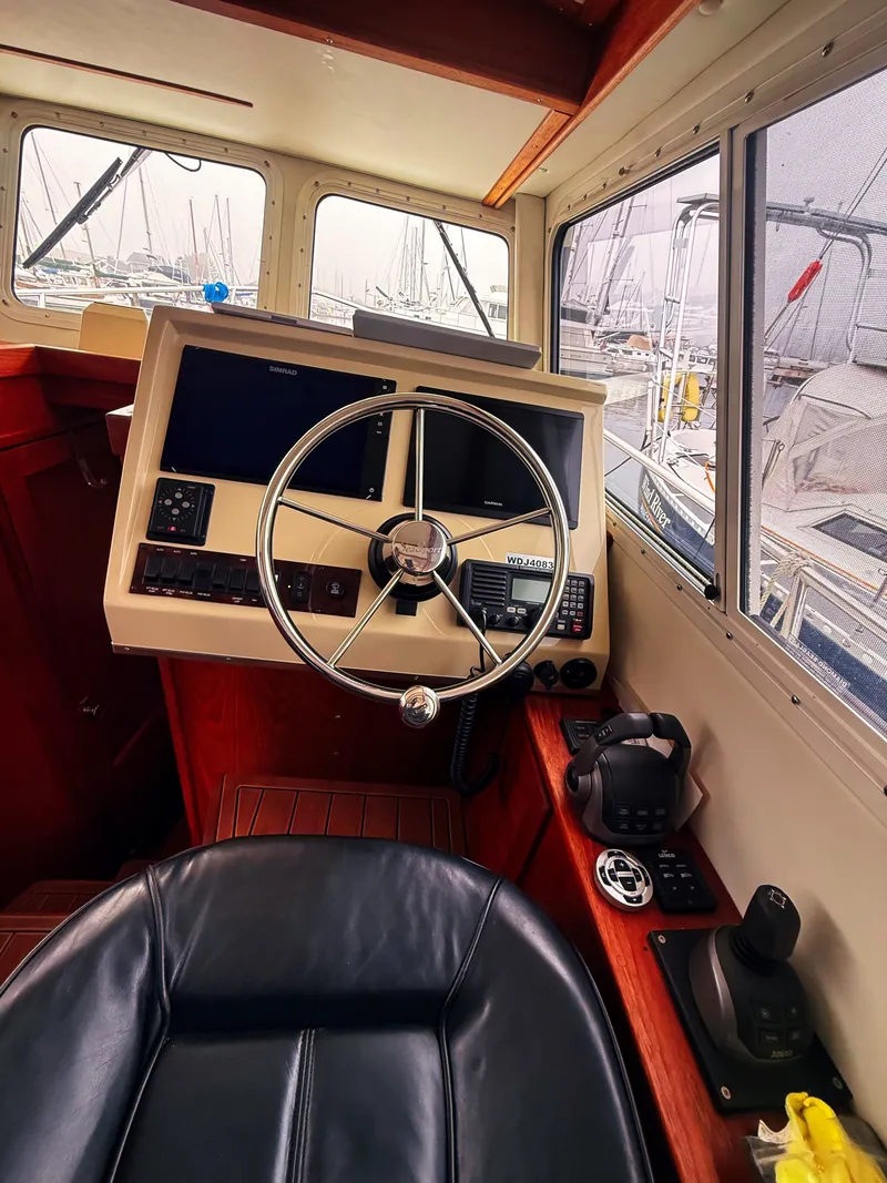 Slide: The Image of The image shows the helm of a 2005 SeaSport Voyager 3000 with a sleek steering wheel and modern electronics. - 4