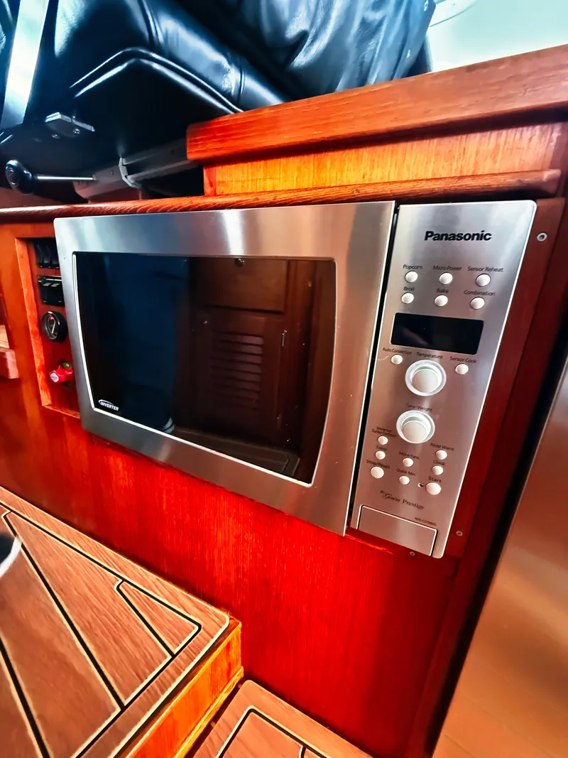 Slide: The Image of A microwave oven is built into a wooden galley, surrounded by sleek wood finishes. - 7