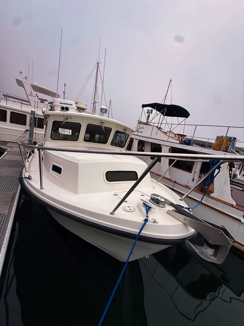 The Image of A 2005 SeaSport Voyager 3000 docked. It features a sturdy design and enclosed cabin. - 0