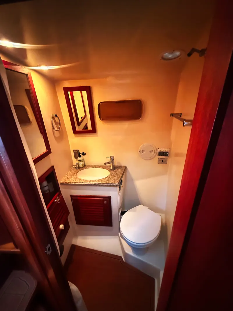 Slide: The Image of Boat bathroom with sink, toilet, and mirror, surrounded by wood paneling. - 16